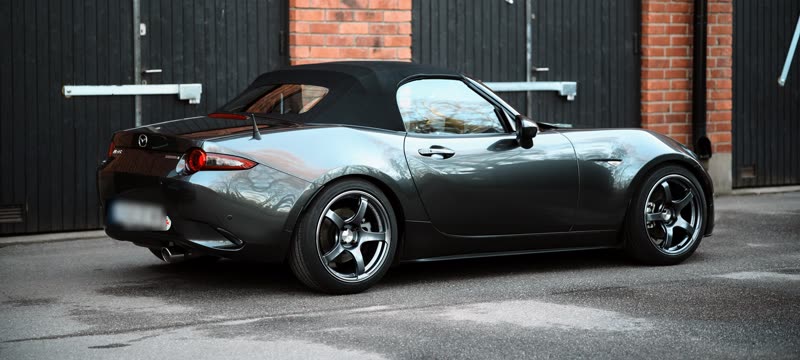 Jon's graphite-grey Mazda MX-5 parked in front of red-brick garages