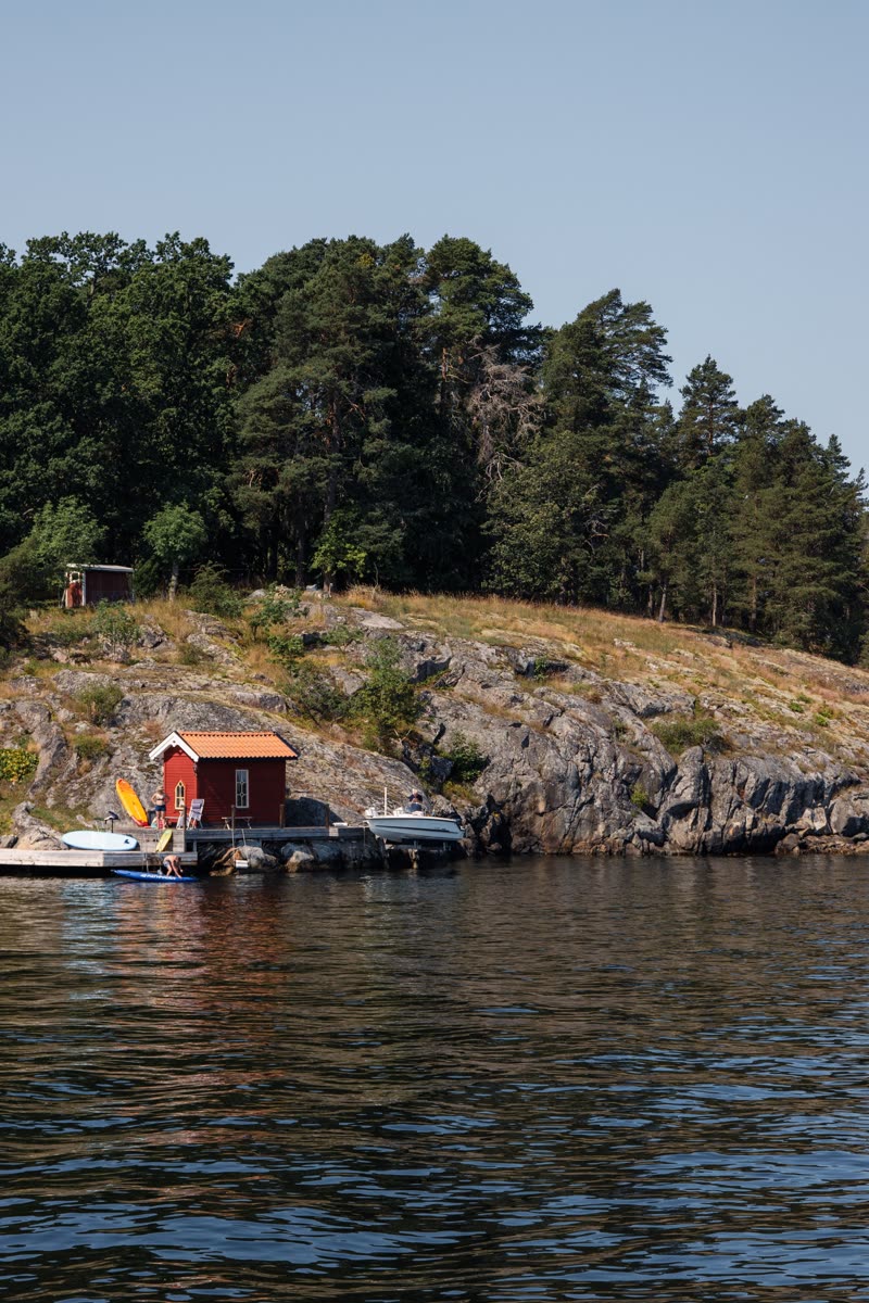 boats and red cabins at the water's edge